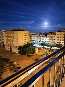 a view of a city at night from a balcony at Nador Skyline Al Matar in Nador