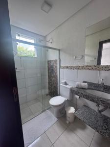 a bathroom with a shower and a toilet and a sink at Pousada da Esdras in Capitólio +22 photos