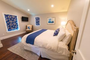 een slaapkamer met een bed en 2 ramen bij The Newport Lofts - 359 Thames Street in Newport