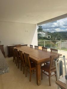 a dining room with a wooden table and chairs at Pousada da Esdras in Capitólio