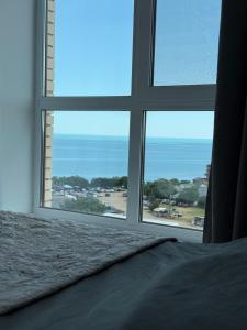 a bedroom with a window looking out at the ocean at Квартира с Видом на Море, жк Парус, 9-3 in Chornomorsk +30 photos