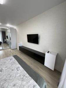 a bedroom with a flat screen tv on the wall at Квартира с Видом на Море, жк Парус, 9-3 in Chornomorsk