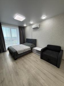 a bedroom with a bed and a couch in it at Квартира с Видом на Море, жк Парус, 9-3 in Chornomorsk