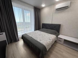 a bedroom with a bed and a large window at Квартира с Видом на Море, жк Парус, 9-3 in Chornomorsk