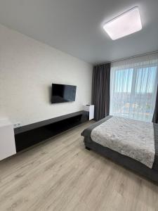 a hotel room with a bed and a flat screen tv at Квартира с Видом на Море, жк Парус, 9-3 in Chornomorsk