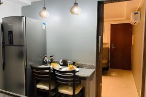 a kitchen with a refrigerator and a table with chairs at Blue Sunset Prime vista do mar e varanda in João Pessoa
