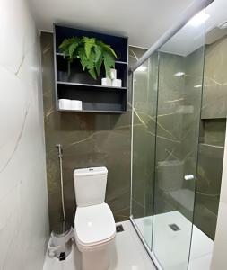 a bathroom with a toilet and a glass shower at Blue Sunset Prime vista do mar e varanda in João Pessoa