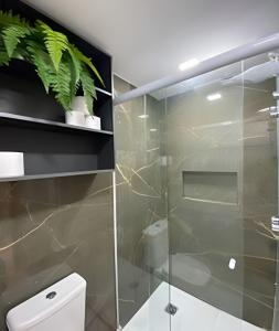 a bathroom with a glass shower stall and a toilet at Blue Sunset Prime vista do mar e varanda in João Pessoa