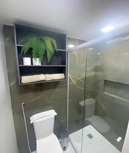 a bathroom with a toilet and a glass shower stall at Blue Sunset Prime vista do mar e varanda in João Pessoa