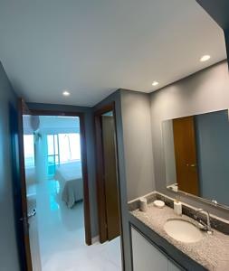 a bathroom with a sink and a mirror and a bed at Blue Sunset Prime vista do mar e varanda in João Pessoa +50 photos