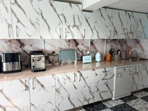 a kitchen with marble walls and a counter with appliances at Vefxos Guest home in Anaklia