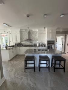 a kitchen with white cabinets and a large island with stools at Room in private house for Rent in Nice Neighborhood in Midlothian