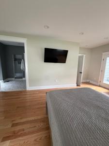 a bedroom with a bed and a flat screen tv on the wall at Room in private house for Rent in Nice Neighborhood in Midlothian