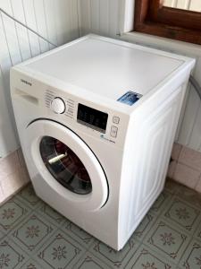 a white washing machine sitting in a bathroom at Vefxos Guest home in Anaklia
