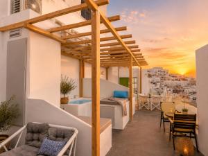 a balcony with a bed and a table and chairs at Cliff Caldera Modern Suites -Volcano, Sunset & Caldera View in Fira