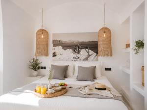 a bedroom with a bed with a tray of food on it at Cliff Caldera Modern Suites -Volcano, Sunset & Caldera View in Fira +51 photos