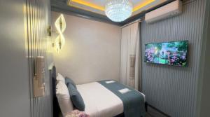 a bedroom with a bed and a tv on a wall at Santa Rio Taxim in Istanbul