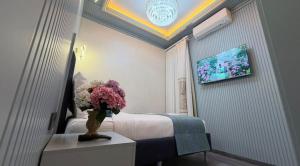 a hotel room with a bed and a vase of flowers at Santa Rio Taxim in Istanbul