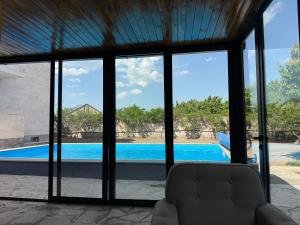 a living room with a view of a swimming pool through windows at Blue Garden in Nor Hachyn