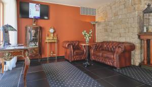 a living room with two leather chairs and a table at Wellness Golf Hotel Morris in Mariánské Lázně