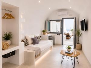 a white living room with a couch and a table at Cliff Caldera Modern Suites -Volcano, Sunset & Caldera View in Fira