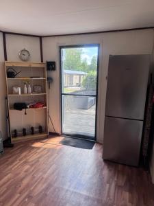 an empty room with a refrigerator and a sliding glass door at Chalet Feanzicht in Earnewâld