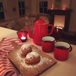 dos donuts en un plato en una mesa con tazas de café en Lutje Hoeske en Tinallinge