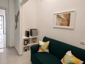 ein Wohnzimmer mit einer grünen Couch und einer Mikrowelle in der Unterkunft Etnera in Trecastagni