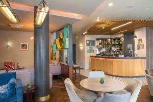 a lobby with tables and chairs and a bar at Holiday Inn York City Centre by IHG in York