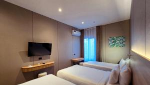 a hotel room with two beds and a flat screen tv at Hotel Bankir Khiva in Khiva