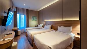 a hotel room with two beds and a desk at Hotel Bankir Khiva in Khiva