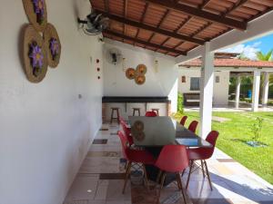 a patio with a table and chairs with a laptop at Summer House in Jijoca de Jericoacoara