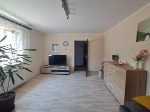 a living room with a flat screen tv and a table at U Podnóża Gór in Nowa Ruda
