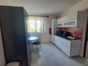 a small kitchen with a table and a window at U Podnóża Gór in Nowa Ruda