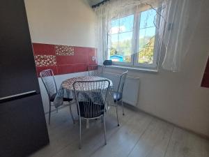 a table and chairs in a room with a window at U Podnóża Gór in Nowa Ruda