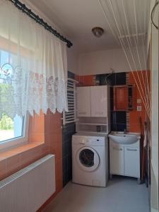 a small kitchen with a washing machine and a sink at U Podnóża Gór in Nowa Ruda +4 photos