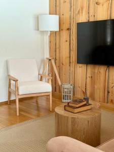 a living room with a tv and a chair and a table at Silver Lodge in Luosto
