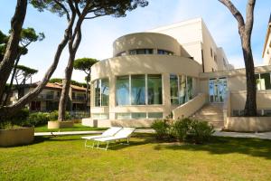 a white house with a bench in front of it at Hotel Terme Marine Leopoldo II TERME & SPA in Marina di Grosseto