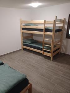 a room with two bunk beds and a tile floor at Rekreačná chata TERASA in Železničná Stanica Šiatoroš