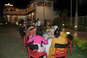 a group of people sitting at a table at night at The Grand Leela Resort in Khopoli +169 photos