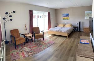 a bedroom with a bed and a table and chairs at 't Westerkwartiertje in Aduard