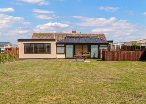 a house with a solar roof on a yard at Unity Beach in Brean