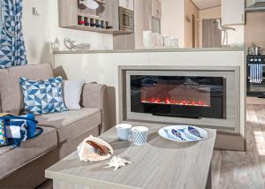 a living room with a fireplace and a table at Unity Beach in Brean