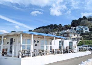 a building with a blue roof on the beach at Millendreath Beach Resort in Looe +41 photos
