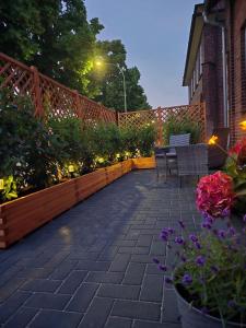 a patio with chairs and flowers and a fence at Lieblingsplatz Bevensen in Bad Bevensen