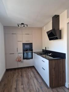 a kitchen with white cabinets and a black counter top at Appartement Pila - Faverges in Faverges +5 photos