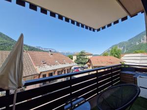 a balcony with chairs and a view of a city at Appartement Pila - Faverges in Faverges