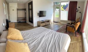 a bedroom with a bed and a living room at 't Westerkwartiertje in Aduard