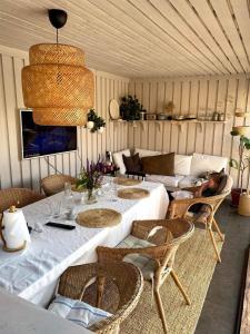 a living room with a table and chairs and a couch at Enplansvilla med pool in Tyresö