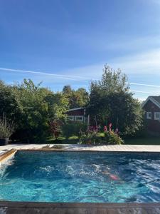 a swimming pool in a yard with a house at Enplansvilla med pool in Tyresö